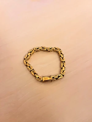 24 karat guldplaterad armband  - Stilrent armband i guldfärgad metall med kraftig kedjelänk och smidig låsning. Armbandet har en klassisk design som ger en lyxig känsla och passar perfekt till dig som gillar statement-smycken. Den är 24karat guldplaterad med.