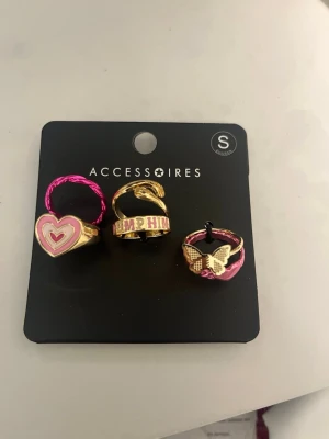 Ringar i olika motiv - Säljer ett set med 6 ringar i guld- och rosa toner. Perfekta för att addera färg till din stil!