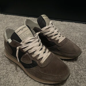 Philippe Model sneakers i mocka - Snygga sneakers från Philippe Model i Skorna har vita snören och en klassisk platt sula. Perfekta för dig som gillar stilrena och exklusiva sneakers med en sportig touch. Kort från Philippe model medföljer samt mörkblåa snören🤗