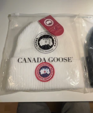 Vit Canada goose mössa - Jag säljer denna feta Canada goose mössan som har tags på och är helt oanvänd. Den är riktigt fett i färgen vit och den är ribbad. Den är även riktigt varm vilket är perfekt nu för vintern.