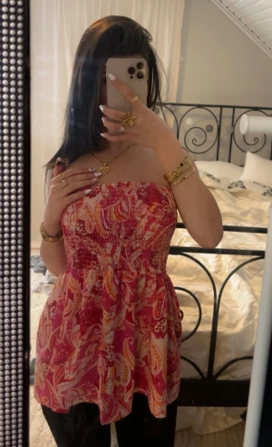 Rosa mönstrad bandeau tubtopp - Säljer en färgstark bandeau tubtopp i rosa och rött. 