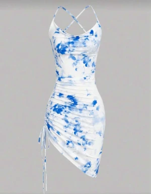 Vit och blå asymmetrisk kortklänning - Superfin kort klänning med blått och vitt blommönster, smala korsade axelband och snörning i sidan. Sitter tight och har en asymmetrisk nederkant som ger en unik look. Perfekt för sommarens alla tillfällen.