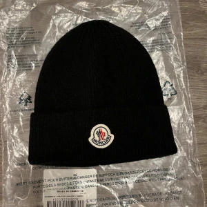 Stilren vintermössa i hög kvalitet - Varm och snygg mössa med klassisk design. Passar perfekt för kalla dagar. Materialet är mjukt och bekvämt, med en logodetalj framtill. Färgen är svart En tidlös modell som passar till alla typer av outfits.