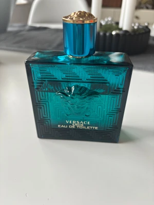 Versace Eros Eau de Toilette 100ml - Versace Eros Eau de Toilette, 100 ml. En ikonisk doft i snygg blå flaska, perfekt för dig som vill sticka ut och visa stil. Originalförpackning medföljer. Det är ungefär 65-70 ml kvar. Nypris: ca 750-900