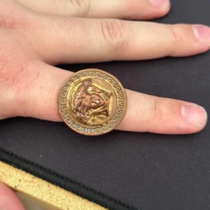 Koppar ring med antik relief - Säljer en ring som är gjord av koppar som jag har sparat i några år.! Det är en Versace ring. Vet inte vad jag kan få för den men lägg gärna bud jag kan polera upp den om det önskas :) 
