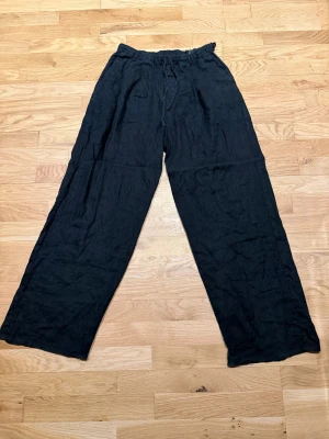 Svarta linnebyxor från Weekday XS - Svarta linnebyxor från Weekday i storlek XS. Byxorna har en relaxed passform med breda ben och snörning i midjan för extra komfort. Perfekta för chill dagar och har en enkel, stilren look som funkar till det mesta. Nypris:- 699 på weekday oftast slutsåld!