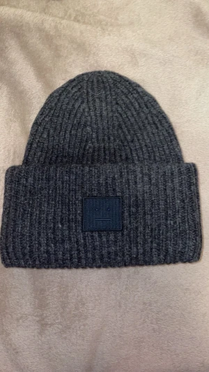 Acne Studios mössa  - Hej! Säljer min gråa Acne Studios mössa som är i ett utmärkt skick då jag vill köpa en ny jacka. Jag kan posta den på torsdag/fredag eftersom jag är bortrest just nu. Ifall men vill mötas upp i Stockholm så slipper man betala frakt och de andra extra kostnaderna👌🏼 vid frågor kom privat🙂