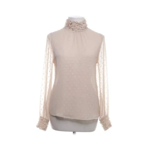 Vacker blus, Zara Basic - Säljer en jättefin blus från Zara Basic med transparenta långärmar och diskret prickigt mönster. Blusen har hög krage och är dekorerad med volanger vid hals och ärmslut. Perfekt för dig som gillar romantiska detaljer och mjuka färger. Storlek S