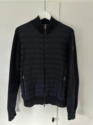 Moncler cardigan - Ett helt otroligt unikt och populärt plagg, En superfin moncler cardigan i storlek L men sitter som M. Nypris på nästan 13 000 kr (se sista bilden) och grymt skick! Inga hål eller fläckar och sitter hur bra som helst på! Tveka inte vid minsta fråga eller fundering och pris ej hugget i sten😎