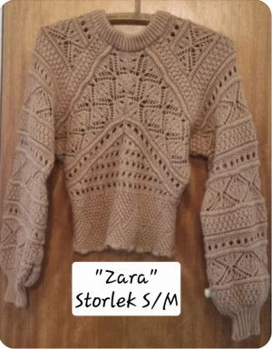 Beige stickad tröja från Zara - Snygg beige stickad tröja från Zara med unikt hålmönster och ribbad rund hals. Tröjan har långärmade ärmar och en croppad passform som ger en trendig look. Perfekt för dig som gillar detaljer och vill sticka ut lite extra.