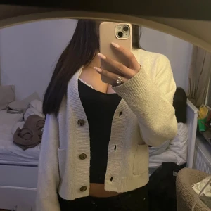 Beige kofta från Uniqlo med knappar - Säljer en beige, mysig kofta från Uniqlo i storlek XS. Koftan har långa ärmar, två fickor framtill och stora bruna knappar. Det är samma tröja som ja sålt innan fast en annan färg oxh har samma passform! 💕