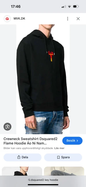 Svart hoodie från Dsquared2 med tryck - Svart hoodie från Dsquared2 med huva och snörning. På bröstet finns ett litet tryck i rött och gult som ser ut som en brinnande nyckel. Tröjan har en klassisk passform och är tillverkad i mjukt material, perfekt för en avslappnad stil.