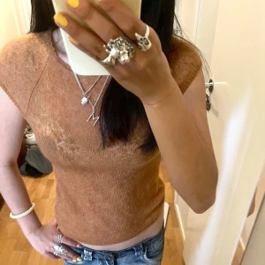 Brun stickad ärmlös topp - Superfin brun orange stickad tröja, perfekt för att styla med jeans elr kjol. Är ganska stretchig, passar xs till m. Själv är jag en s. Skulle hellre mötas, så det inte behövs att betala frakt och så kan ja få pengarna direkt! 🫶🏼💞