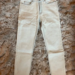 Ljusblå jeans Acne Studios - Snygga ljusblå skinny jeans från Acne Studios i modellen Row Bleached. Jeansen har klassisk femficksdesign, raka bakfickor och är tillverkade i en mjuk bomullsblandning med lite stretch för extra komfort.