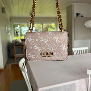 Guess rosa mini väska 💕 - ÄKTA supersöt rosa Guess mini väska/plånbok med vitt mönster och guldig kedja!! 