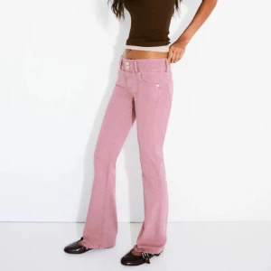 Rosa lågmidjade bootcut jeans - Skit coola jeans som inte kommer till användning. OBS de är slitningar längst ner på båda benen.  Midjemått: 36cm Innerbenslängden: 79cm