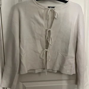 Vit stickad topp Gina Tricot - Säljer en vit stickad topp från Gina Tricot med snygg snörning framtill. 