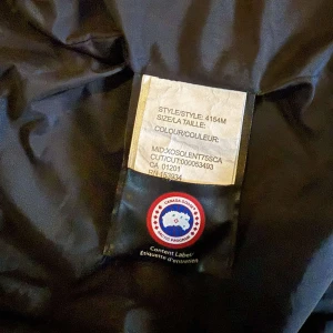 Vit väst från Canada Goose - Säljer en vit väst från Canada Goose. Västen har klassisk design med Canada Goose-logga på insidan och är tillverkad i slitstarkt material som håller dig varm under kalla dagar. Perfekt för dig som vill ha både stil och funktion. Pris kan självklart diskuteras.
