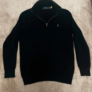 Svart stickad tröja Polo Ralph Lauren - Säljer nu min Svart stickade tröja från Polo Ralph Lauren med halv dragkedja. Perfekt nu till hösten. Skick 9/10 Använd drygt 3 gånger då den vart för liten på mig. Priset är inte hugget i sten