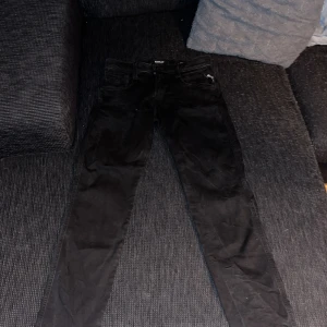 Svarta Replay jeans, midja 28/32 - Svarta jeans från Replay med klassisk femficksdesign och snyggt Replay-märke bak i midjan. Modellen har smal passform och raka ben. Tillverkade i bomull med en skön stretch. Perfekta svarta jeans för dig som gillar stilrena och tidlösa plagg. Knappt använda. Hör av dig vid några frågor