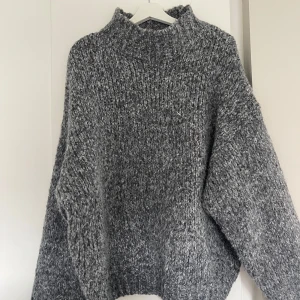 Grå stickad oversized tröja - Mysig grå stickad tröja med grov struktur och hög krage. Tröjan har en oversized passform och långa ärmar, perfekt för kyliga dagar🩶🩶🩶