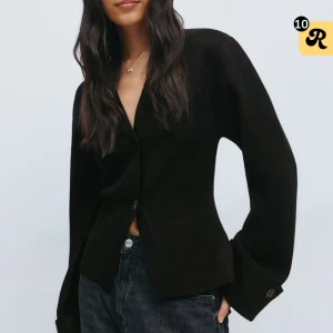 Stickad kofta  - Stilren svart kofta från Gina Tricot med v-ringning och två knappar framtill. Koftan har långa ärmar med breda manschetter och knappdetalj. Modellen är något croppad och har en klassisk, enkel design som passar till mycket. Endast använd en gång. 