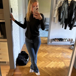Blåa bootcut jeans midwaist - Säljer ett par klassiska blå jeans med normal passform och bootcut. Jeansen har fem fickor. Midjan är midwaist 