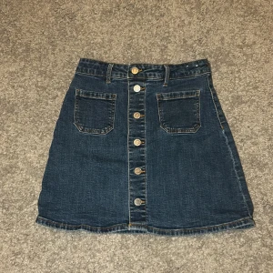 Jeanskjol H&M - Riktigt snygg Mörkblå jeanskjol ifrån H&M. Säljes pågrund av att jag ej använder den längre. Använd någon gång förra sommaren men inte alls efter det. I nytt skick.