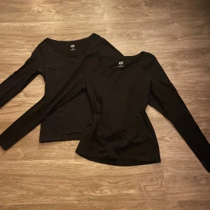 2 Svarta långärmade toppar - Två svarta långärmade toppar från 157 med rund halsringning. De har en enkel och stilren design som passar till det mesta. Materialet känns mjukt och stretchigt, perfekt för lager-på-lager eller som basplagg.