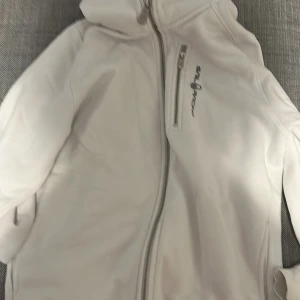 Vit vindjacka från Sail Racing - Säljer en stilren vit vindjacka från Sail Racing med dragkedja framtill och hög krage.  I storlek M och använd ett enstaka gånger. Mvh Vincent 