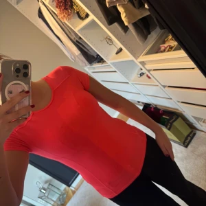 Neon träningstopp i syntetmaterial - Sportig neon topp med rund hals och korta ärmar.