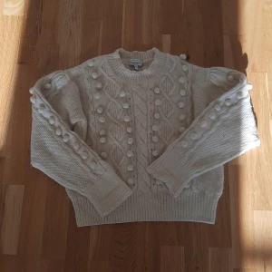 Vit stickad tröja & Other Stories M - Superfin vit stickad tröja från & Other Stories Paris Atelier. Tröjan har ett chunky flätmönster och coola bollar längs ärmar och framstycke. Varm och mysig till vinter bomull och alapca would innehåller den kom med prisförslag!