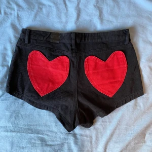 Svarta korta shorts från Lazy Oaf - Jättefina unika svarta mini shorts från Lazy Oaf med hjärtan på bakfickorna. Köpta på Vinted men tyvärr för stora för mig som brukar ha på mig S ;-;