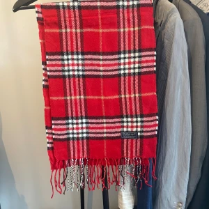 Burberry halsduk  - En sjukt skön halsduk från burberry i en najs julig röd färg. 10/10 skick. Priset är 599. Skriv gärna vid fundering! Materialet är Kashmir alltså 100% lamm ull.