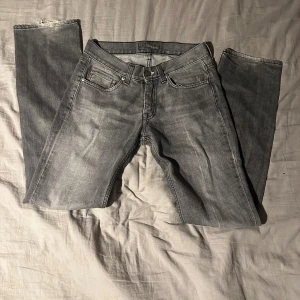 Grå Acne Jeans Mic Blacktrash 29/32 - Säljer ett par grå jeans från Acne Jeans i modellen Mic Blacktrash. Jeansen har klassisk femficksdesign, raka ben och normal passform. Tillverkade i 100% bomull med snygg tvättad look och diskreta slitningar. Perfekta för en avslappnad stil.