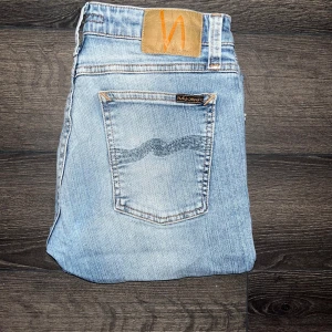 Nudie Jeans Skinny Lin jeans - Säljer ett par Nudie Jeans Skinny Lin i ljusblå tvätt. Jeansen har klassisk femficksdesign, skinny fit och är tillverkade i 98% ekologisk bomull och 2% elastan för extra stretch. Midja 36cm, längd 93cm. Ifall det inte finns någon bild i annonsen där jag bär plaggen jag säljer så är det för att jag ej kan ha storleken heller passformen, så kolla måtten för storlek och googla på modellnamnet för passform 😉måtten som mäts kan vara missvisande med någon cm. s2