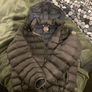 Svart pufferjacka från Colmar - Säljer en svart pufferjacka från Colmar med huva och dragkedja framtill. Jackan har ett quiltat mönster och två sidofickor med dragkedja. Perfekt för kalla dagar och har en snygg, modern look. Storleken är M men passar S hör av er vid fler frågor! Pris kan diskuteras 