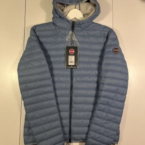 Helt Ny Colmar Jacka Herr Ljusblå - Stilren och exklusiv dunjacka från Colmar, känd för sin kvalitet och italienska design. Jackan är i deras klassiska och eleganta ljusblåa färg med huva och med deras ikoniska Colmar-emblem på ärmen. Perfekt till både vardag men även uppklädda tillfällen – lätt, varm och otroligt bekväm. Självklart finns kvitto!  🧥 Storlek: 50/M 🌟 Skick: Helt ny, aldrig använd – lappar kvar! 💰 Nypris hos Colmar: 3 500 kr 🔥 Lyxig känsla till ett mycket bättre pris – perfekt till hösten/vintern