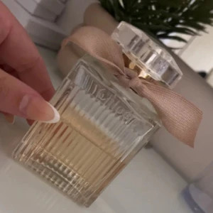 Chloé  parfym med rosett - Stilren och elegant parfym från Chloé med en söt rosett på flaskan. Ca 50% återstår 100 ml nypris närmare 2000kr