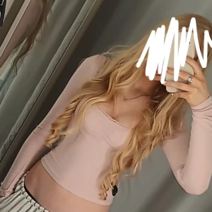 Ljusrosa långärmad topp  - Supersöt ljusrosa långärmad topp från h&m med ribbad struktur, v-ringad spetskant och rynkdetalj framtill. Toppens material är mjuk bomullsmix och den har en slim passform som sitter snyggt. Perfekt för dig som gillar romantiska och feminina vibes.