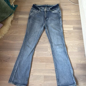 Blå bootcut jeans med detaljerade bakfickor - Snygga blå jeans med bootcut-modell och coola detaljerade bakfickor med knappar. Jeansen har klassisk femficksdesign,  är tillverkade i mjukt denimtyg. Perfekta för dig som gillar en avslappnad men ändå trendig look. Inte för korta tjejer men bättre för längre tjejer! Från SHEIN