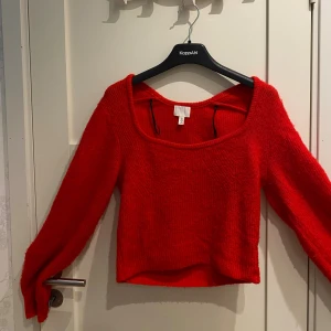 Röd stickad tröja från H&M - Superfin röd stickad tröja från H&M med fyrkantig ringning och lång ärm. Tröjan är lite croppad och har en mjuk, fluffig känsla. Perfekt för att liva upp din höst- eller vintergarderob med en poppig färg.
