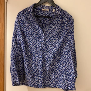 Blå leopardmönstrad skjorta Esprit XL - Snygg blå skjorta från Esprit med unikt leopardmönster i vitt. Skjortan har klassisk krage och knappar framtill. Tillverkad i mjuk bomull som känns skön mot huden. Perfekt för dig som vill sticka ut med ett coolt mönster och fräsch färg.