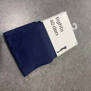Mörkblå tights från Gina Tricot - Säljer ett par mörkblå tights från Gina Tricot i färgen Peacoat. De är 40 denier och tillverkade i en mjuk blandning av 91% polyamid och 9% elastan. Perfekta för att ge en snygg look till din outfit.