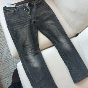 Levi's 501 svarta jeans - W31 L32 - Säljer ett par svarta fräscha Levi's 501 jeans med klassisk knappgylf och raka ben. Jeansen har en snygg tvättad look, W31 L 32, inga defekter. Nypris 1050. 
