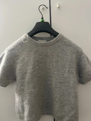 Grå stickad t shirt  - Fin knappt använd grå stickad T-shirt ifrån Gina 