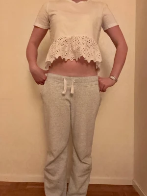 Vit croppad blus med volang - Söt vit croppad blus med korta ärmar och volang nertill. Blusen har broderade detaljer och en luftig känsla, perfekt för varmare dagar. Passar dig som gillar en feminin och trendig stil. Säljs eftersom den tyvärr är för liten för mig💗