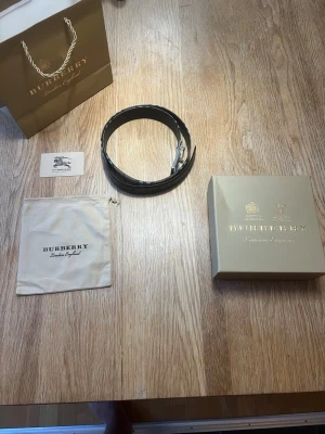 Burberry bälte  - Burberry Herr Bälte tillverkat i svart läder, storlek 95 cm. Bältet är designat för män och har en klassisk stil med märkets signaturdetaljer. Produkten levereras med originalförpackning och tillbehör.  Har haft bältet i typ ett år men har inte använt det ofta