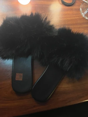 Svarta pälstofflor - Säljer mina pälstofflor som tyvärr inte passar. Helt nya och endast testade inomhus. Köparen står för frakten. 