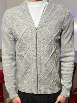 Grå stickad kofta från Peak Performance - Grå peak kofta/lite bredare lång modell/nopprig på armbågarna lätt att fixa